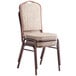 A Lancaster Table & Seating tan fabric banquet chair with a crown back and brown metal frame.