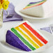 A slice of David's Cookies 5-color rainbow cake on a plate.