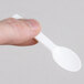 A person holding a Royal Paper white plastic taster spoon.
