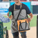 A man opening a Choice small orange insulated cooler bag.