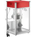 A red and silver Carnival King commercial popcorn machine with a glass door.