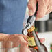 A person using an Acopa Waiter's Corkscrew to open a bottle of beer.