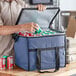 A man putting cans into a Choice navy insulated cooler bag.