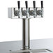 A Beverage-Air wine kegerator with four silver metal taps and black handles.