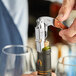 A person using an Acopa Flex Waiter's Corkscrew to open a bottle of wine.