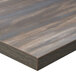 A close up of a BFM Seating chestnut melamine table top with matching edge.