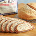 A loaf of sliced bread on a table next to a bag of Bob's Red Mill Unbleached Artisan Bread Flour.