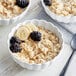 A bowl of Bob's Red Mill whole grain rolled oatmeal with bananas and blackberries on top.