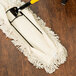 A Carlisle dry mop pad on a wood floor.