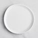 A white GET Enterprises Riverstone melamine coupe plate with an irregular round shape.