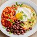 A plate of beans, eggs, and tomatoes with Goya Adobo seasoning.