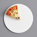 A slice of pizza on a white 9" corrugated pizza circle.