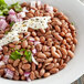 A bowl of Goya pinto beans and onions.