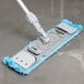 A Unger SmartColor mop holder with a blue handle.