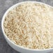 A bowl of Goya Canilla enriched long grain rice on a gray surface.