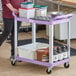 A purple Choice utility cart with food containers on the shelves.