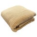 A beige Oxford Jaipur hotel blanket with a tan honeycomb pattern.