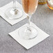 A pair of wine glasses on Hoffmaster FashnPoint white beverage napkins.