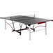 A Stiga table tennis table with a black and red top and net on wheels.