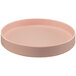 A Cal-Mil Hudson blush melamine plate with a raised rim on a table.