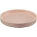 A round pink melamine plate with a raised rim on a white background.