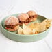 A Cal-Mil Hudson matcha melamine plate with three mini sliders and chips.