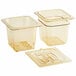 A group of Cambro amber plastic 1/6 size food pans with colander pans and lids.