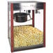 A Paragon Pastime Pop popcorn machine with a metal bowl of popcorn inside a wooden cabinet.