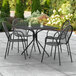 A black square outdoor table with chairs on a patio.