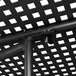 A close up of a black metal Lancaster Table & Seating outdoor table with ornate legs and a grid top.