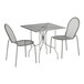 A Lancaster Table & Seating Harbor Gray outdoor table with ornate legs and 2 chairs.