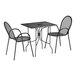 A Lancaster Table & Seating black metal rectangular outdoor table with ornate legs and two arm chairs.