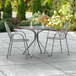 A Lancaster Table & Seating Harbor Gray outdoor table and chairs on a patio.