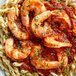 A plate of pasta with shrimp and Regal Hot Italian Seasoning on a white background.