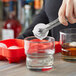 A person using a red Choice silicone ice mold to make sphere ice cubes.