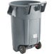 A Rubbermaid grey trash can with wheels.