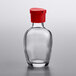 A clear glass Town Round soy sauce bottle with a red lid.