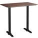 A Lancaster Table & Seating rectangular bar height table with a textured walnut top and black legs.
