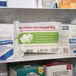 A white box with blue and red text that reads "Medi-First Bloodstopper Compress" on a white shelf with medical supplies.