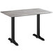 A Lancaster Table & Seating rectangular outdoor table with textured gray top and black legs.