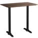 A Lancaster Table & Seating rectangular bar height table with black textured farmhouse base plates.