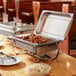 A buffet table with three stainless steel chafing dishes.