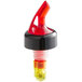 A TableCraft red and yellow measured liquor pourer stopper.