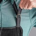 A person wearing a black Outset suede leather apron.