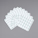 A pack of 12 white dish cloths with green windowpane patterns.