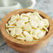 A wooden bowl filled with Cacao Barry Heritage Zephyr White Chocolate pistoles.