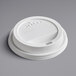 A close-up of a white plastic Dart Traveler hot cup lid with a sip hole.