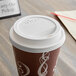 A Dart white paper cup lid with a sip hole on a coffee cup.