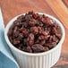 A bowl of Thompson raisins on a table.