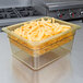 A Cambro amber plastic food pan with french fries in it on a counter.